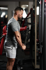 Fototapeta na wymiar Fitness man doing triceps workout in the gym