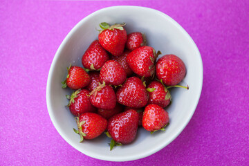 Top view shot of fresh ripe strawberries on glitter pink background