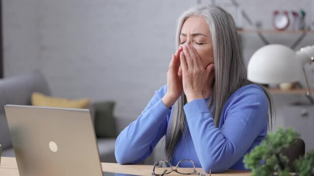 Depressed mature woman overworked on laptop computer. Tired worker recieved bad online news about dismissal from work. Financial crisis, burnout syndrome, overworking, depression, apathy.