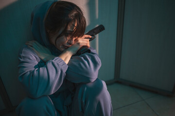 Woman holding a gun and crying in dark