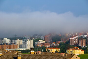 Panoramic view across rooftops with apartment buildings shrouded in sea fog Santander Cantabria Spain June 2021