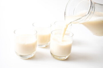 Pouring fresh white milk from bottle into a glass. Healthy food concept.