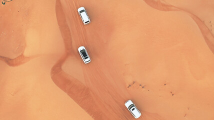 AERIAL. Hight flight above car. Desert safari car sand dunning in the Dubai desert during sunset