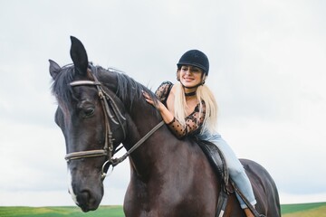 Fototapeta premium Beautiful girl riding a horse in countryside.
