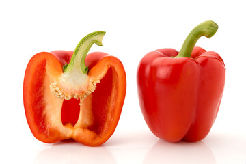 One whole red bell pepper and one cut in half in cross section, isolated on white