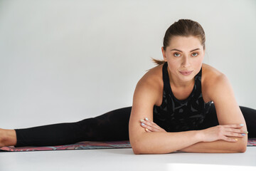 Fototapeta na wymiar Flexible young white woman in sportswear exercising