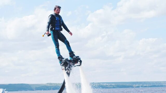 Sportive man flying above the river