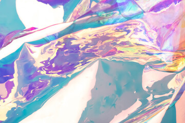 Defocused iridescent holographic background. Blurred colorful texture of wrinkled foil.