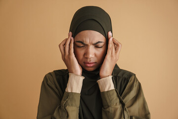 Black muslim woman with headache rubbing her temples