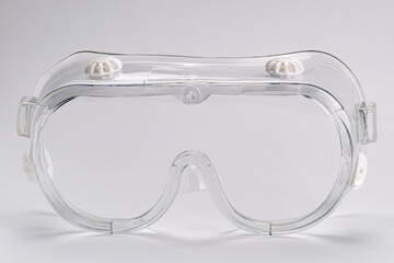Side view of transparent safety protective goggles isolated on white background.