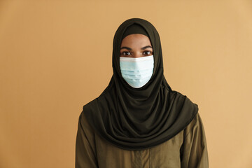 Black muslim woman posing in face mask and hijab