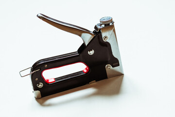 Furniture black construction stapler on a white background.