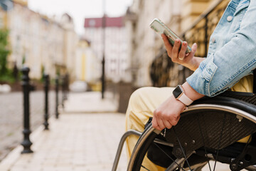 Woman using mobile phone while sitting in wheelchair