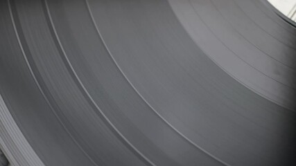 Slow motion. A close-up of a spinning vinyl record. Start and stop of disk rotation. Vinyl record texture and background. Top view