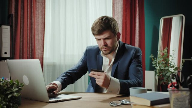 Business Concept - Portrait Handsome mature Businessman working with confident face, using credit card, entering pincode. Experienced CEO leader of the enterprise, freelancer work in home office.