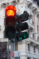 Traffic light with red stop light in urban environment. Blurred building in the background. Milan,...