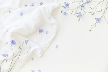 Blooming flax flowers on a white background on light-colored textiles.