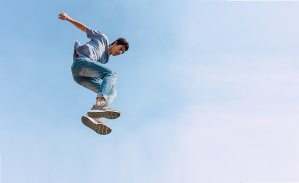 Man doing parkour trick against blue sky