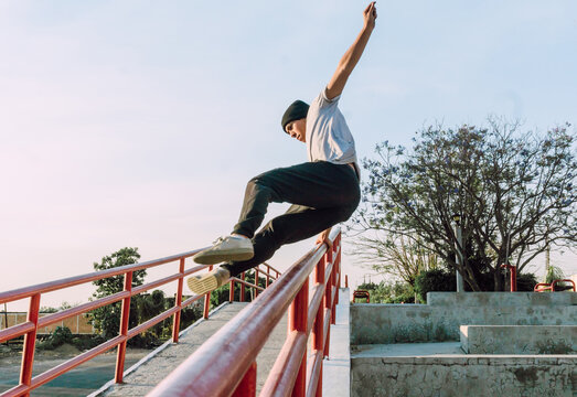 Man jumping over railing and showing parkour tricks