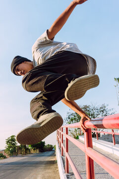 Man jumping over railing and showing parkour tricks