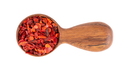Dried red chili flakes in wooden spoon, isolated on white background. Chopped chilli cayenne pepper. Spices and herbs. Top view.