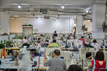 View of busy sewing room in Chinese shoes factory