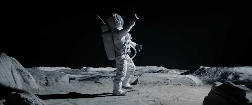 Astronaut searching for cellular or wi-fi signal while walking on Moon surface. Shot with 2x anamorphic lens