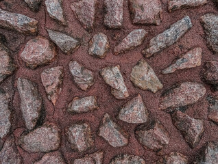 Background with granite pebbles in sand
