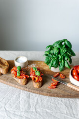 Classic bruschetta with tomatoes on a wooden cutting board.