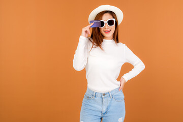 A beautiful Asian woman wearing a white long sleeve sweater and jeans, carrying a paper bag with items bought from a department store.