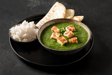 Palak paneer of spinach and cheese isolated on a black background. Traditional Indian cuisine. Close up.