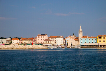Fototapeta na wymiar Kroatien, Fazana. Blick vom Wasser auf die idyllische Stadt mit dem Kirchturm und den bunten Häuserfronten