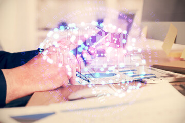 Double exposure of man's hand holding and using a digital device and brain hologram drawing. Data concept.