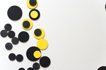 overlapping wooden shapes hand painted in black and yellow - arranged in a loose composition on a light ground - photographed in a top-down orientation