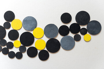 wooden shapes hand painted in yellow, silver gray, and flat black - arranged in a loose composition on a light ground - photographed in a top-down orientation