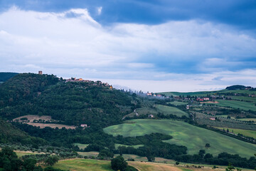 Landschaft in Italien Toskana Hügel mit Feldern und Wald im Hintergrund Häuser