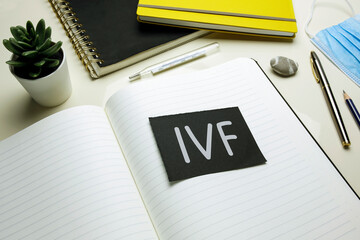 IVF (In Vitro Fertilization) written on open notebook