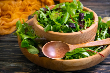 green salad leaves in a plate on a wooden background