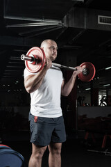 Male athlete lifts the barbell