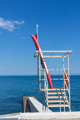 Fototapeta premium Rescue tower and boat on the pier. view of the sea coast, city beach. Vertical