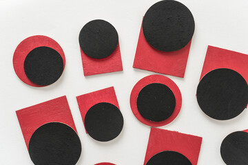 painted black and red shapes on a light background 