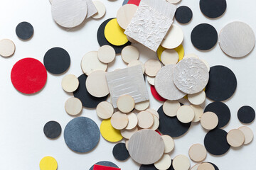 laser-cut plywood shapes hand painted in red, yellow, pearl white, silver black and flat black loosely arranged on white - photographed from above in a flat lay style