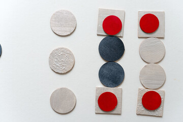 laser-cut plywood shapes hand painted in red, silver black, and pearl white loosely arranged on white - photographed from above in a flat lay style