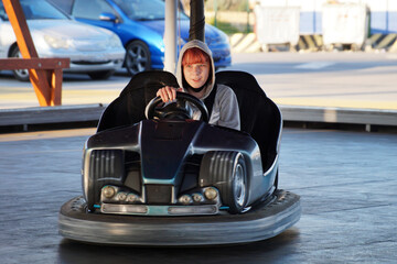 teen girl riding an electric kart in an amusement park