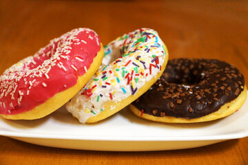 multicolored donuts with glaze on a white plate