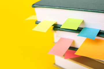 Books with bookmarks on color background, closeup