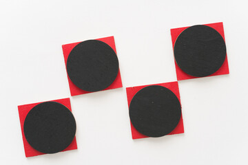 painted black and red shapes on a light background 