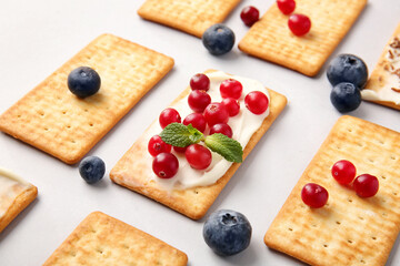 Tasty crackers with berries on grey background, closeup