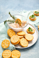 Composition with tasty crackers and sauce on color background