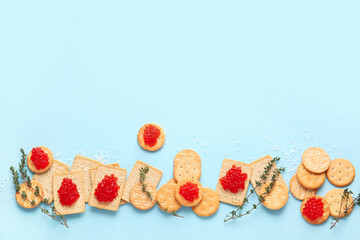 Tasty crackers with red caviar on color background